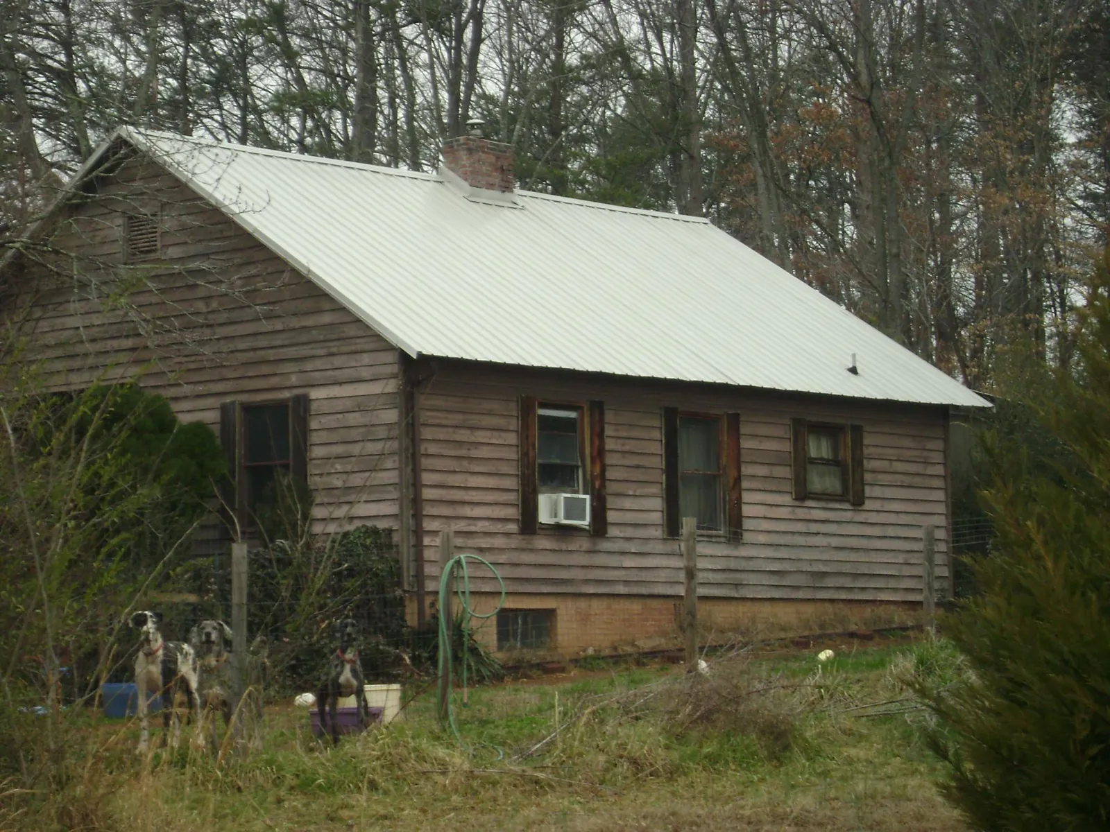 White metal roof on an old wood sided farmhouse, from a Metal Roof Installation job in Akron